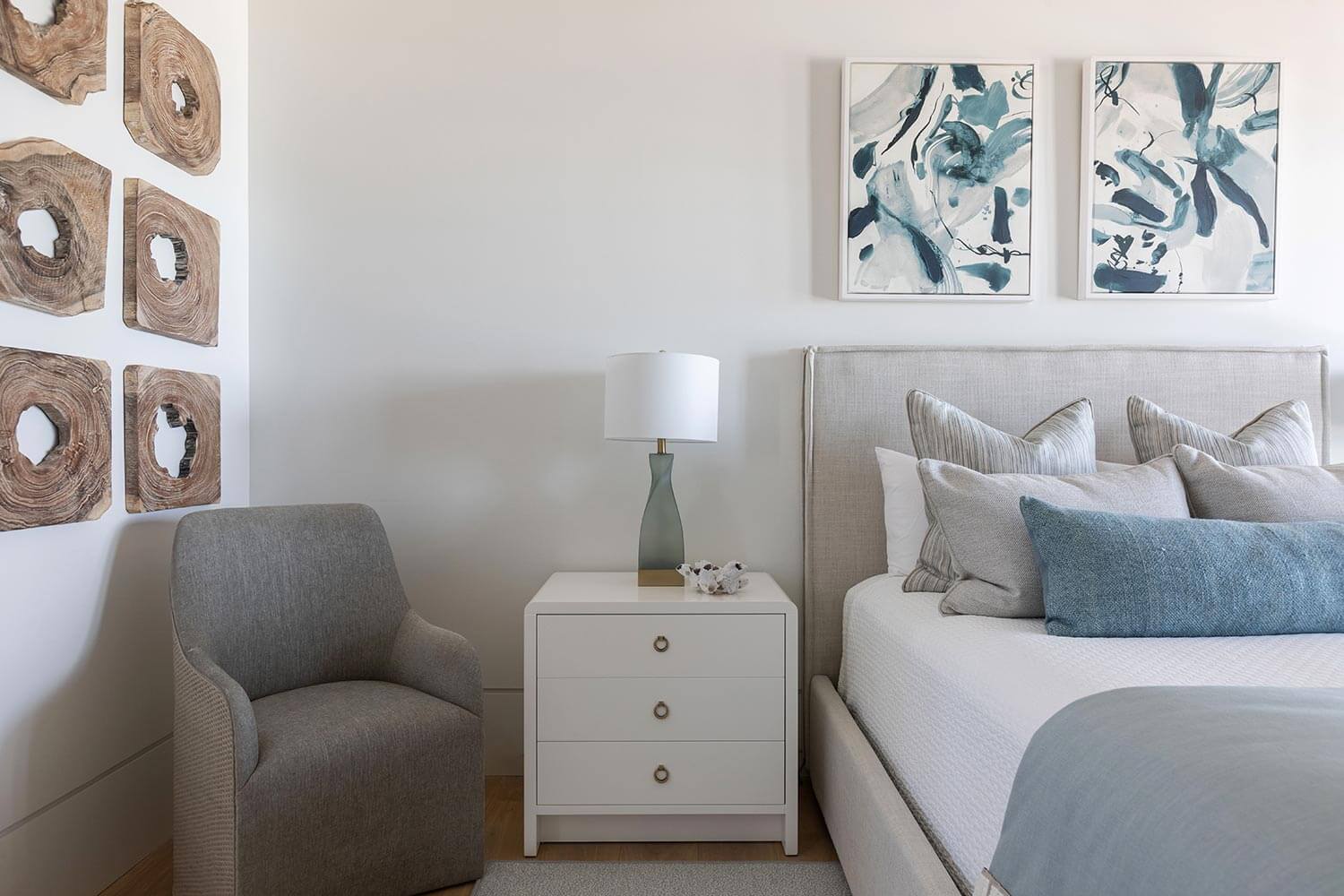 Coastal bedroom embracing 30A design style through organic wall accents, soft neutral upholstery, and a serene beach-inspired palette